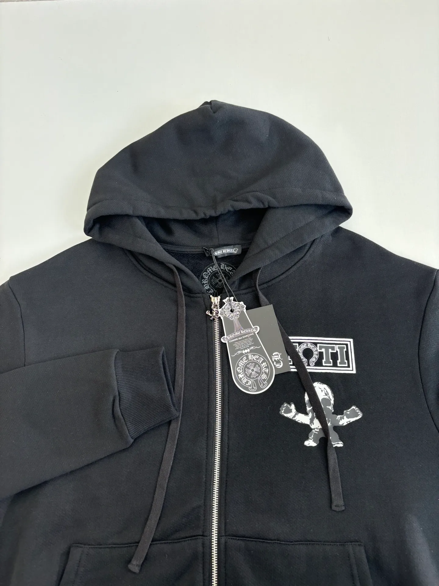P426 Chrome Heart*/Chrome Heart Jiugongge skull hooded zipper sweatshirt is made of high-quality cotton fabric, soft and skin-friendly, and has good breathability. The overall color is classic black, which sets a low-key and versatile style tone. The simple print pattern on the left chest on the front includes letters and cartoon skull images. The design is simple but highly recognizable, showing an uninhibited personality and attitude. Size: S/M/L/XL